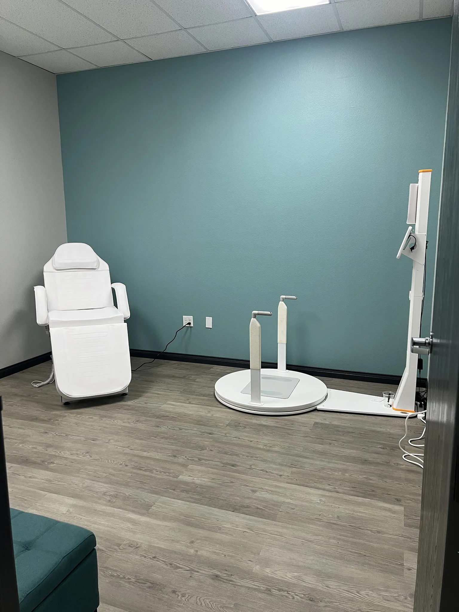 Wellness clinic treatment room with white chair
